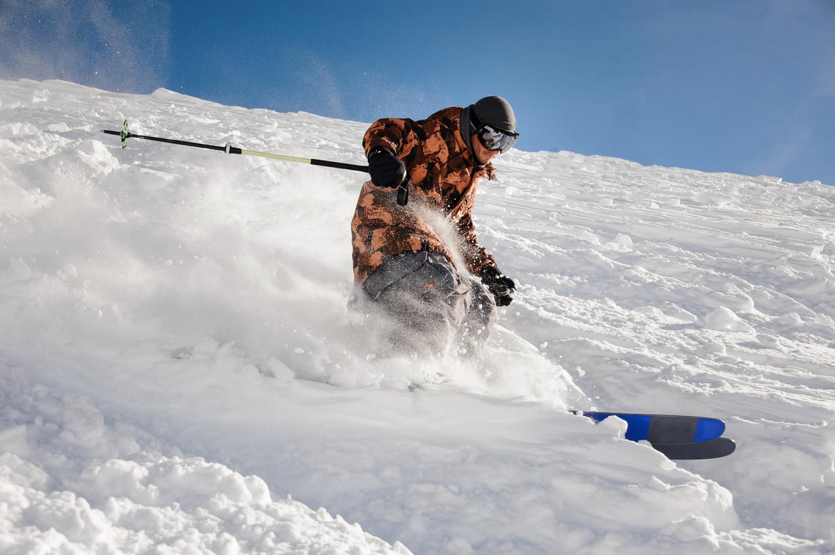 Heliskiing Kazakhstan — pro skier on a steep descent in the Altai Mountains